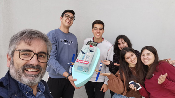 Leraar Alexandre Gomes en zijn leerlingen met hun robotboot. 